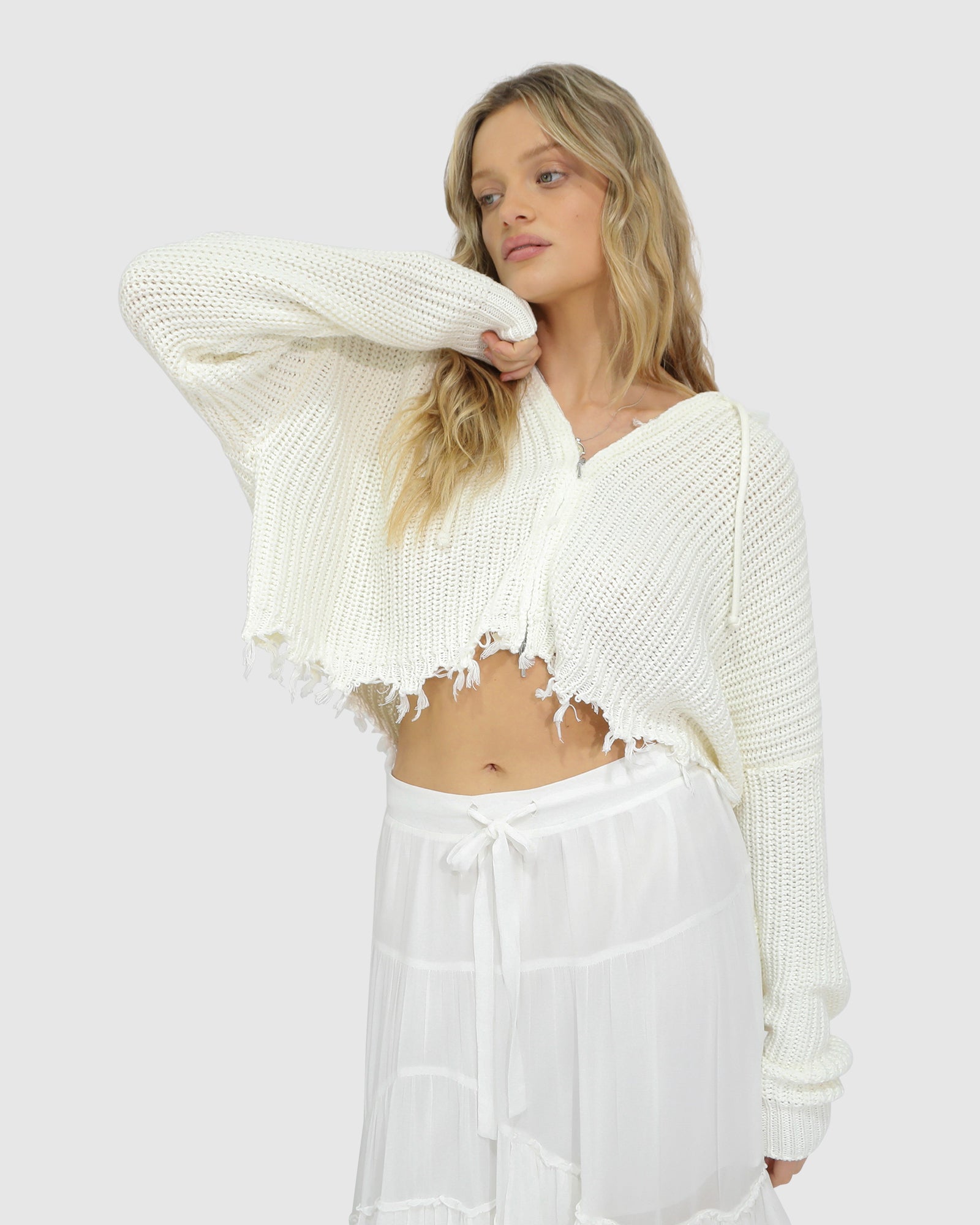 Fringe hem close-up of the Another Love Fringe Knit Zip Cardigan in cream, featuring textured knit fabric and raw-edge style – Belle and Bloom cardigan detail shot.