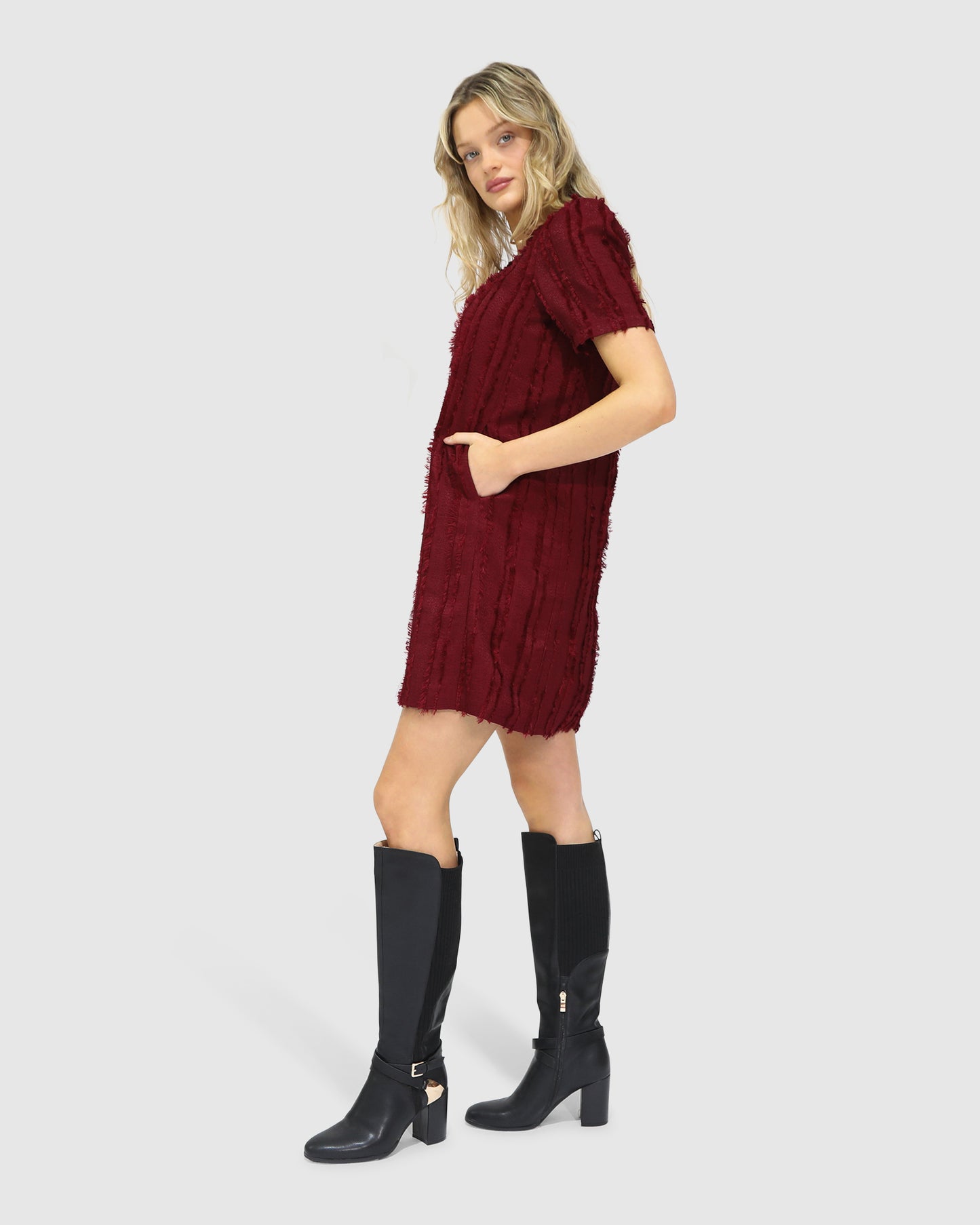 Side view of the Solana Boho Fringe Mini Shift Dress in burgundy, highlighting the textured weave.