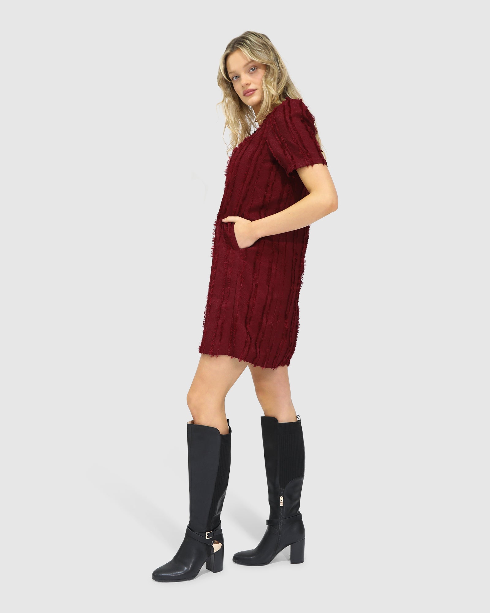 Side view of the Solana Boho Fringe Mini Shift Dress in burgundy, highlighting the textured weave.
