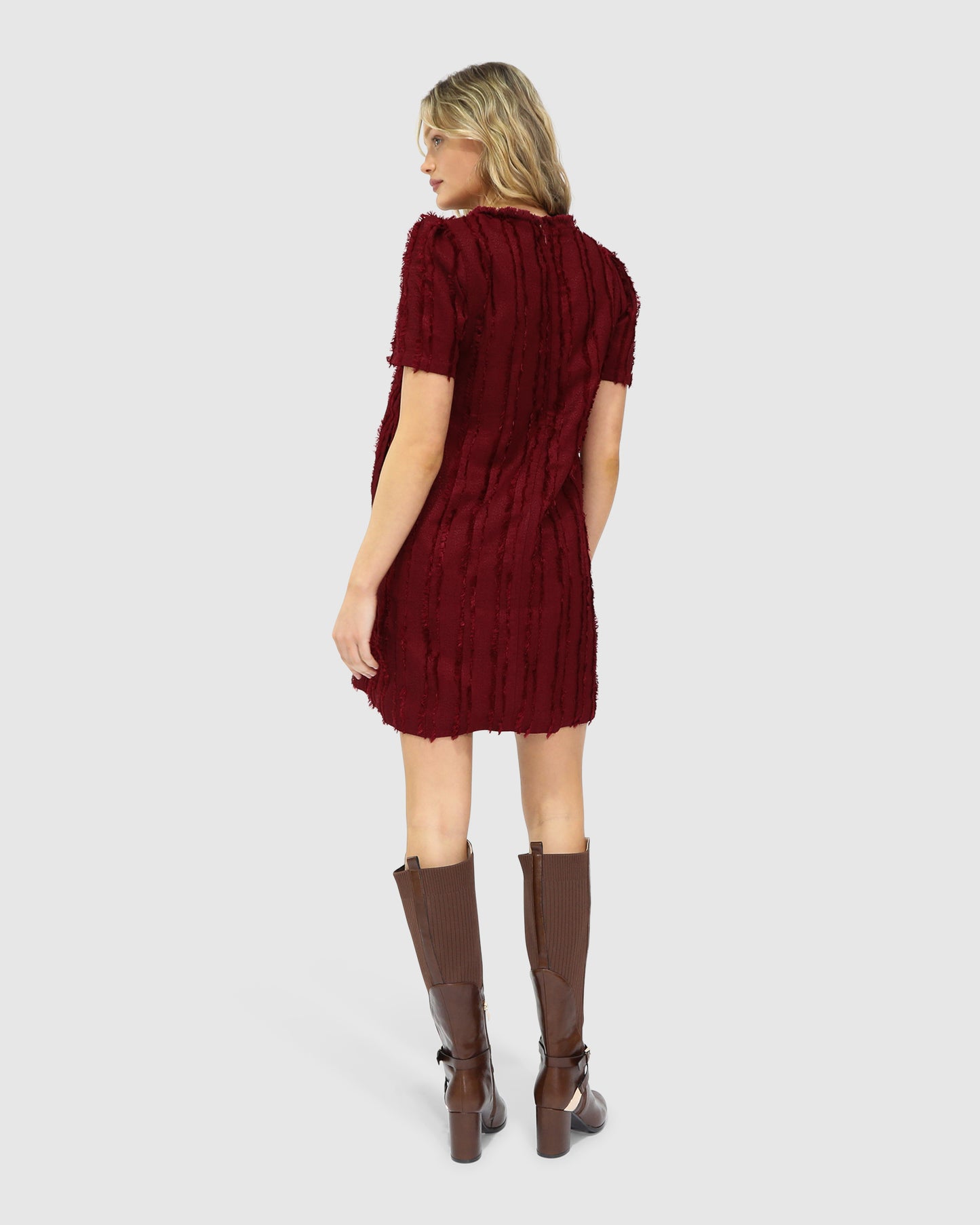 Back view of the Solana Boho Fringe Mini Shift Dress in burgundy, highlighting the hidden side-seam pocket and textured weave.