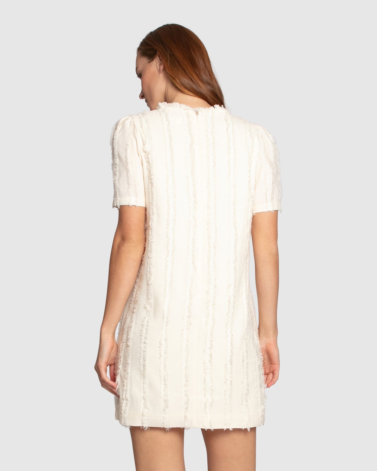 Back view of the Solana Boho Fringe Mini Shift Dress in cream, highlighting the hidden side-seam pocket and textured weave.