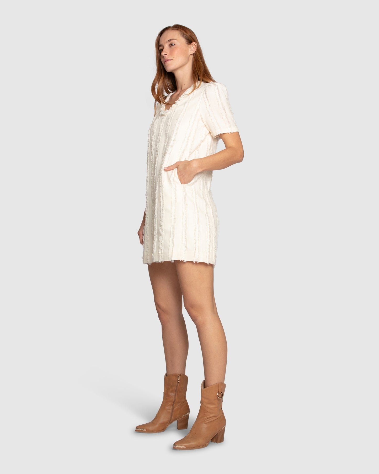 Side view of the Solana Boho Fringe Mini Shift Dress in cream, highlighting the textured weave.