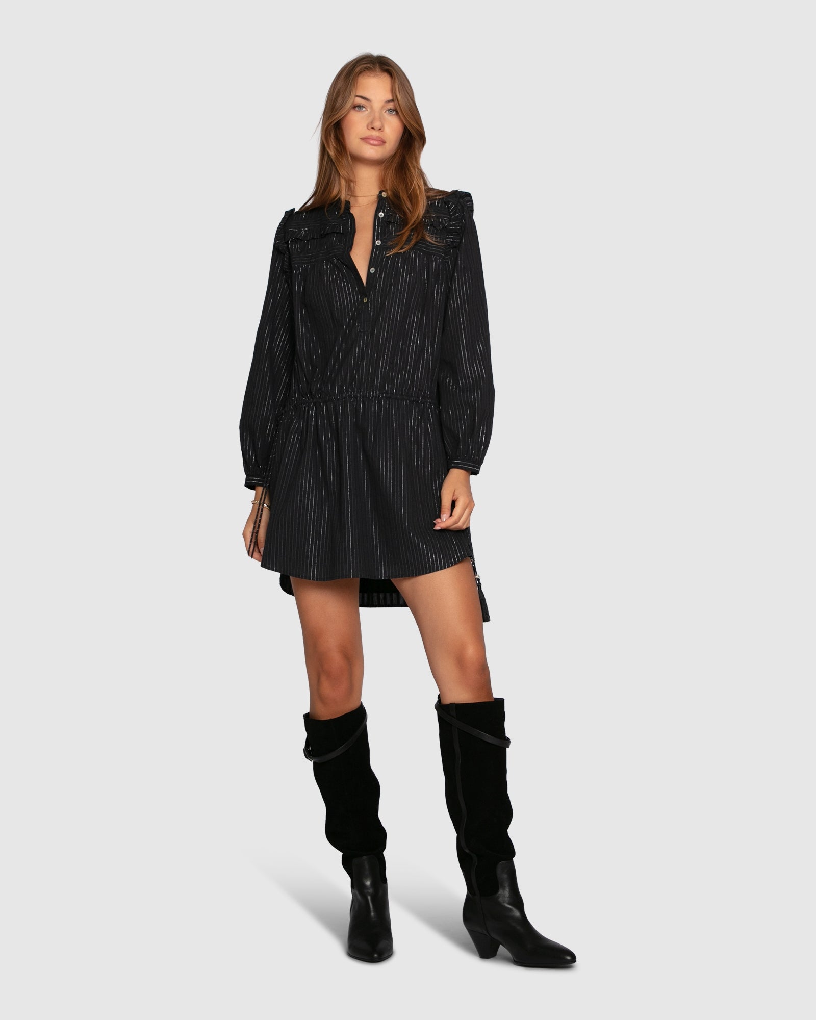 Woman wearing long sleeve black mini dress with lurex stripes