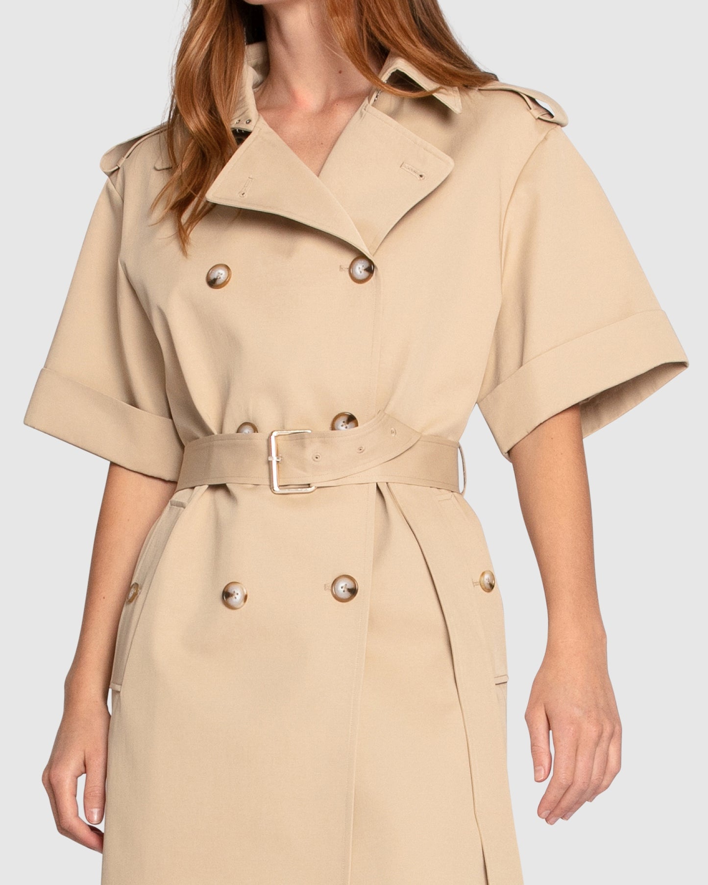 Close-up of Belle & Bloom Dust & Daring Short Sleeve Trench Style Dress in beige, highlighting double-breasted buttons, wide lapel collar and waist belt.
