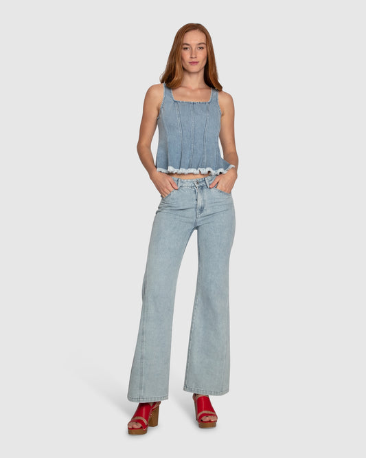 Woman wearing Belle & Bloom Hold Me Brave Denim Top, featuring vertical seams, square neck and fringed hemline