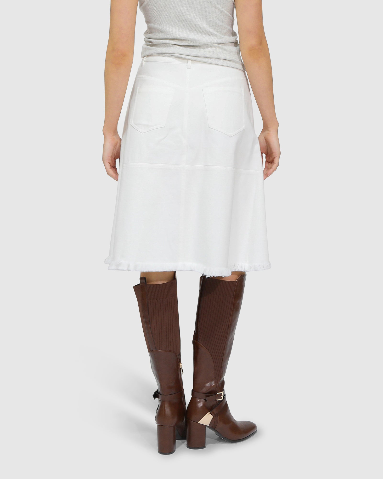 Back view of Belle and Bloom Let Me Wander off white denim midi skirt, showcasing clean seams and raw hem finish.