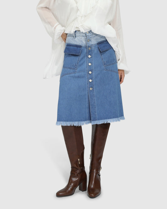 Close-up of raw hem and stonewash denim fabric texture on Belle and Bloom Let Me Wander midi skirt.