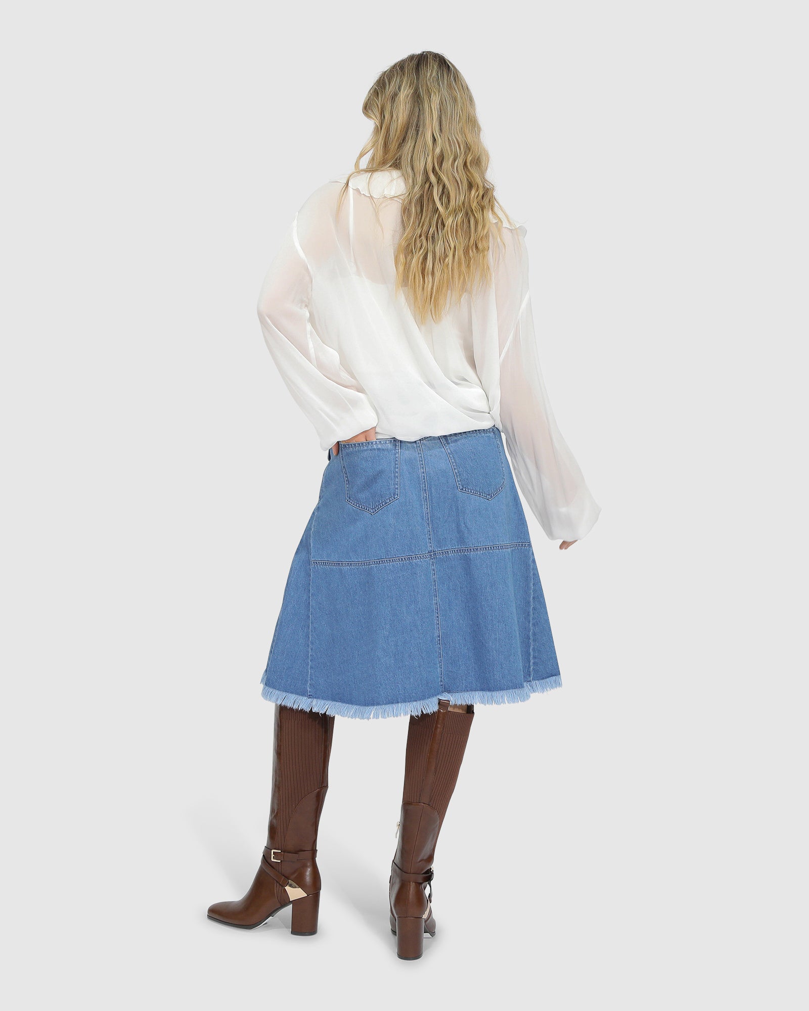 Back view of Belle and Bloom Let Me Wander stonewash denim midi skirt, showcasing clean seams and raw hem finish.