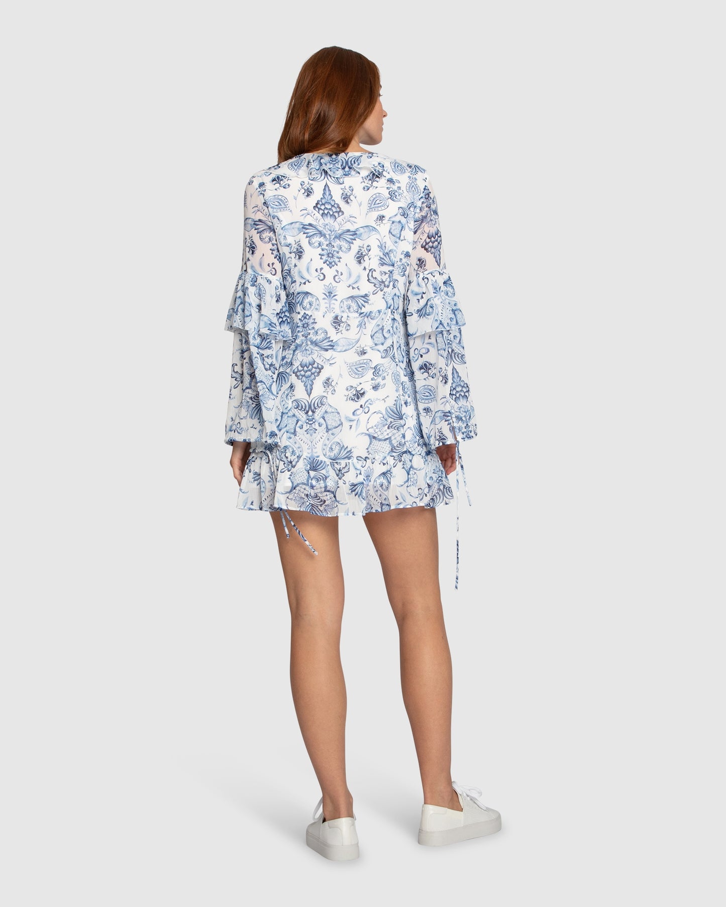 Back view of Mad About You mini dress in blue print by Belle & Bloom, highlighting the invisible side zipper and ruffled details.