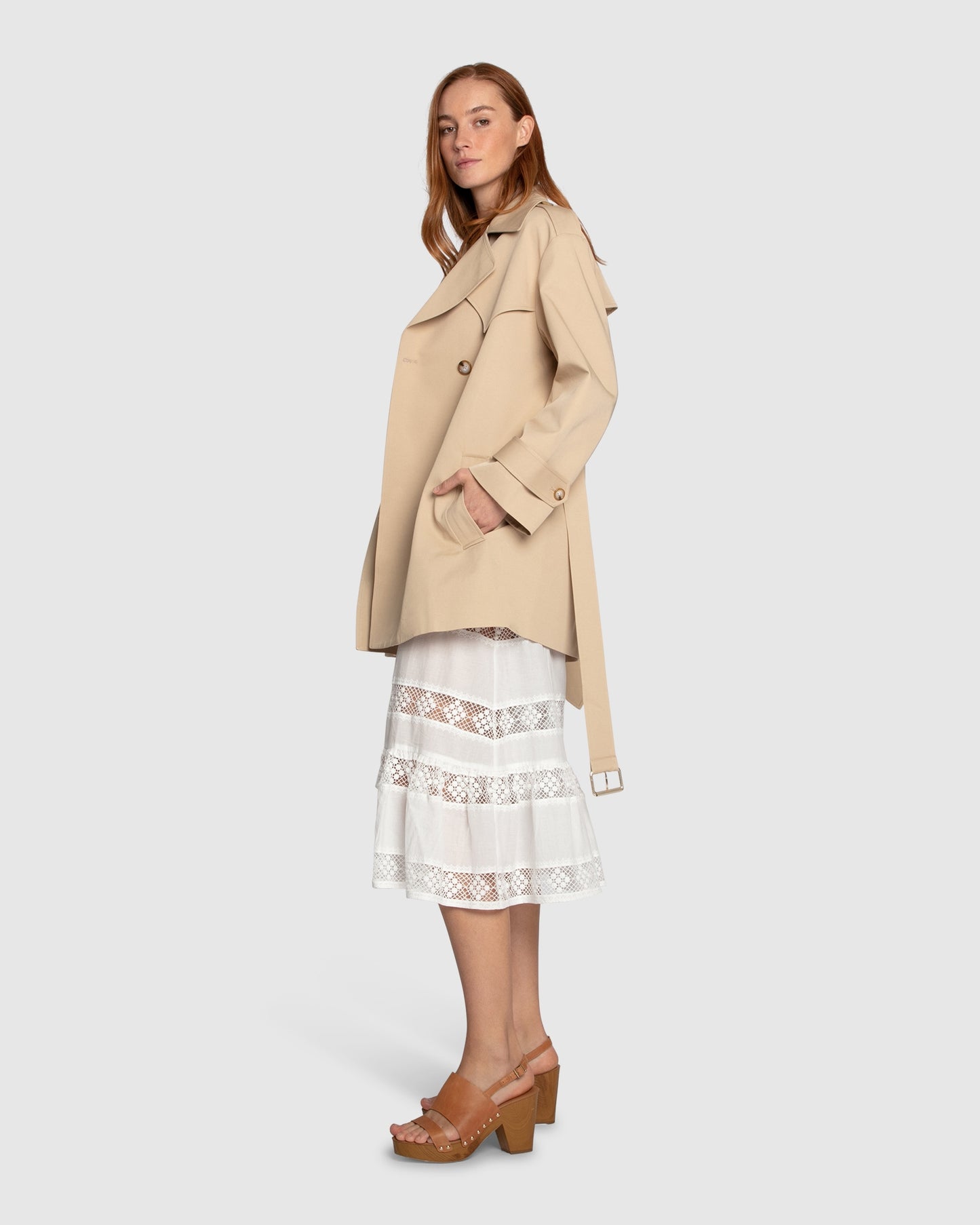 Side view of woman wearing the Whispers of Verona Trench Coat in light camel, highlighting the belted waist, structured silhouette, and soft drape – Belle and Bloom trench coat.
