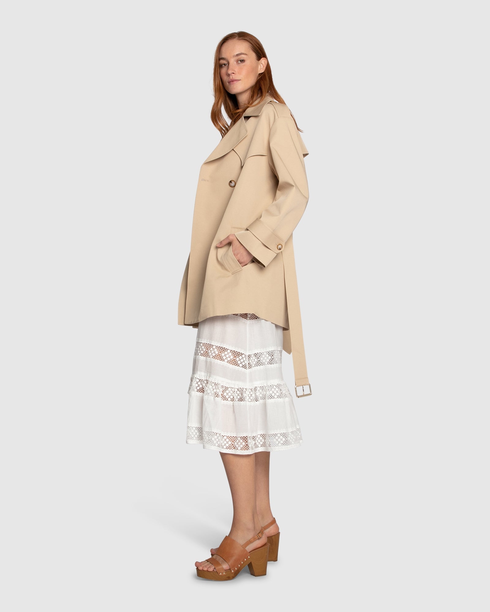 Side view of woman wearing the Whispers of Verona Trench Coat in light camel, highlighting the belted waist, structured silhouette, and soft drape – Belle and Bloom trench coat.